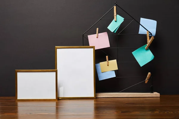 Quadros em branco perto do suporte metálico com notas e pinos pegajosos — Fotografia de Stock