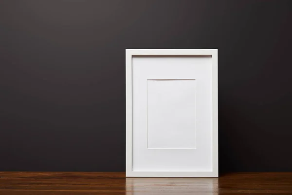 White decorative, square frame on wooden table — Stock Photo