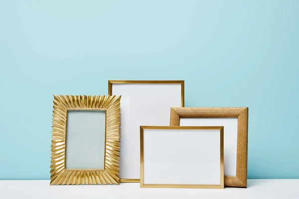 Blank square decorative frames near blue wall — Stock Photo