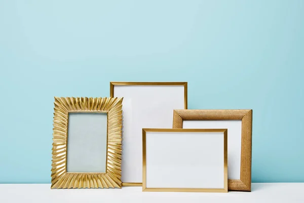 Quadros decorativos quadrados em branco perto da parede azul — Fotografia de Stock