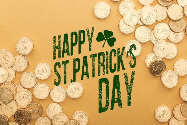 Top view of golden coins near happy st patricks day lettering on orange background — Stock Photo