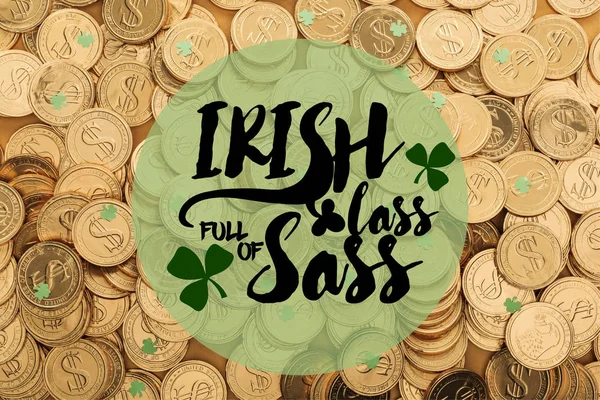 Сверху вид золотых монет с долларовыми знаками и зелеными маленькими трилистниками рядом с ирландской девушкой, полной дерзости — стоковое фото