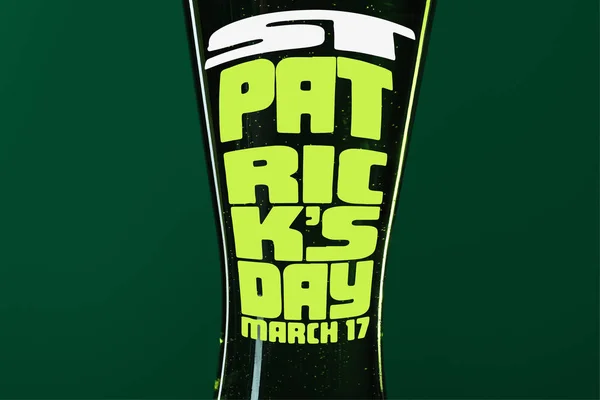 Gros plan de verre de bière avec st patrick lettrage jour sur fond vert — Photo de stock