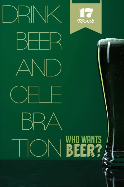 Copo de cerveja com espuma perto de beber cerveja e celebração lettering no fundo verde — Fotografia de Stock