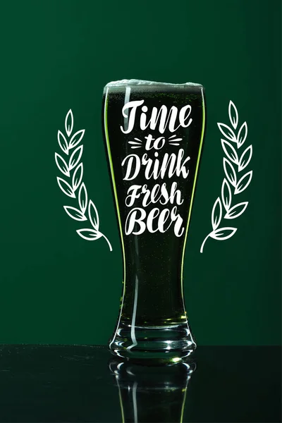 Bicchiere di birra con il tempo di bere birra fresca lettering su sfondo verde — Foto stock