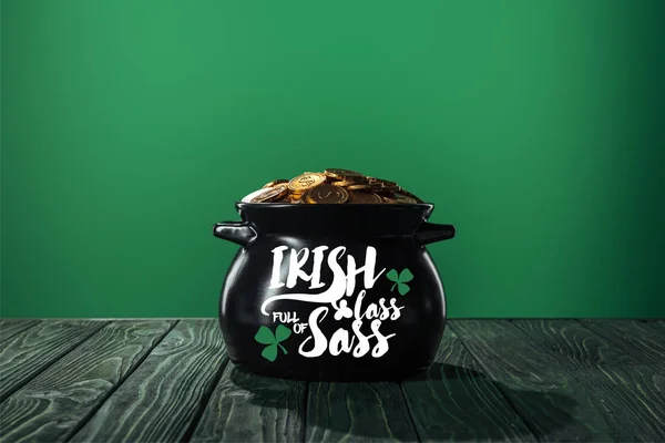 Pièces d'or en pot noir avec irish lass plein de lettrage sass sur fond vert — Photo de stock
