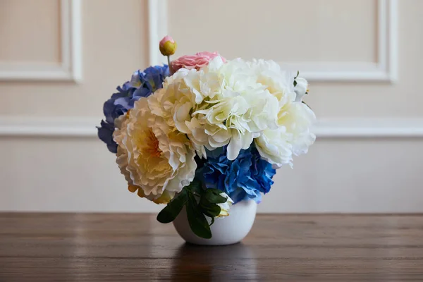 Hydrangea and piones in white vase on wooden table at home — Stock Photo