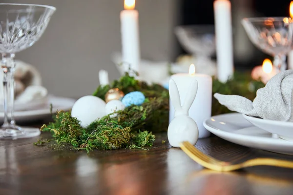 Focus selettivo di muschio verde e coniglietto decorativo sul tavolo in legno a casa — Foto stock