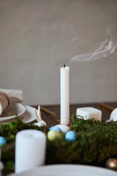 Foco seletivo de vela e placas perto do musgo na mesa de madeira em casa — Fotografia de Stock