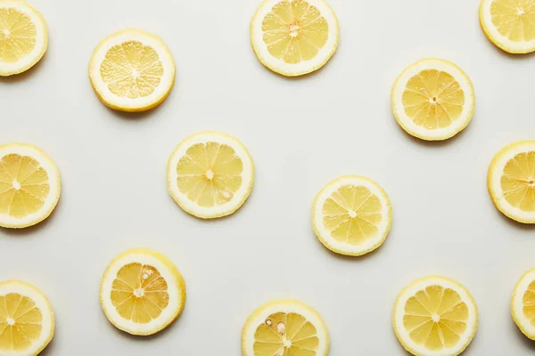 Vista superior de jugosas rodajas de limón sobre fondo gris - foto de stock