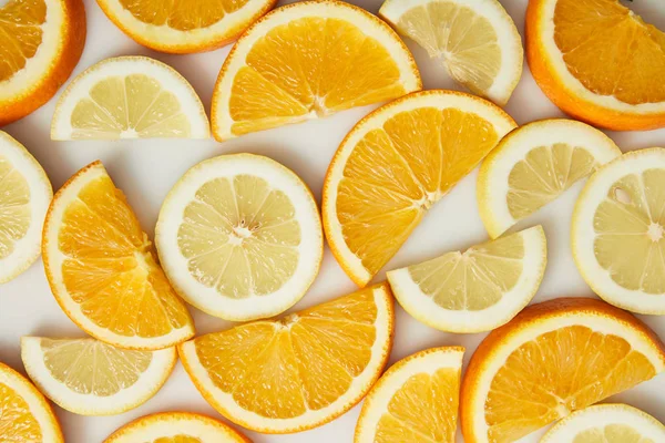 Vista superior de rodajas de naranja y limón sobre fondo blanco - foto de stock