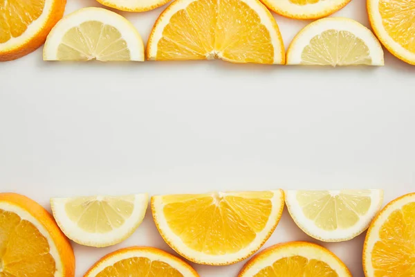 Acostado plano con rodajas de naranja y limón sobre fondo blanco - foto de stock
