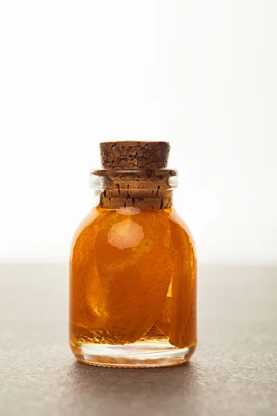 Botella de vidrio de aceite esencial orgánico con fruta cortada aislada en blanco - foto de stock