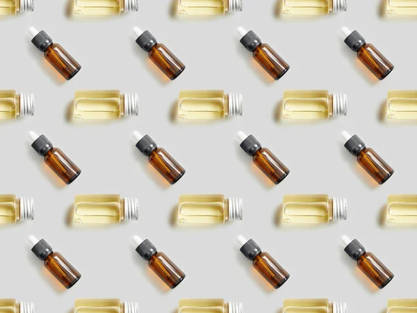 Flat lay with glass bottles of essential oil on grey background — Stock Photo