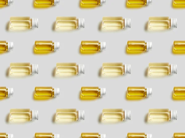 Top view of glass bottles with essential oil on grey background — Stock Photo