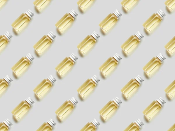Flat lay with bottles of essential oil on grey background — Stock Photo