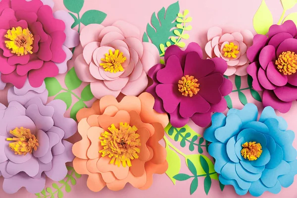 Vue du dessus des fleurs et feuilles colorées en papier sur fond rose — Photo de stock