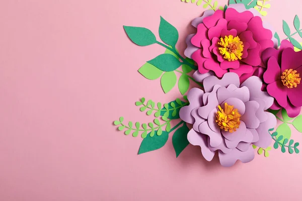 Top view of flowers and paper leaves on pink background — Stock Photo