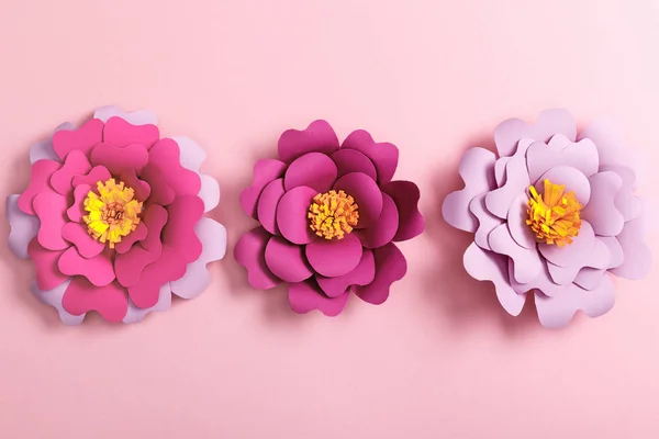 Vista superior de flores de papel multicolores sobre fondo rosa - foto de stock