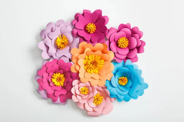 Top view of colorful paper flowers on grey background — Stock Photo