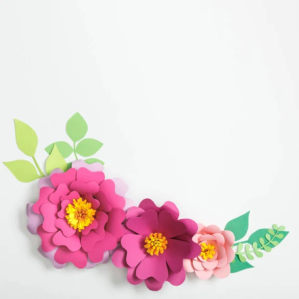 Top view of multicolored paper flowers and leaves on grey background — Stock Photo