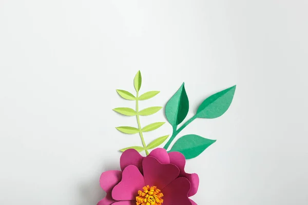 Vista superior de flor de papel rosa y plantas verdes sobre fondo gris - foto de stock