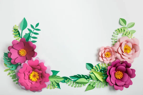 Top view of different paper flowers and green plants with leaves on grey background — Stock Photo