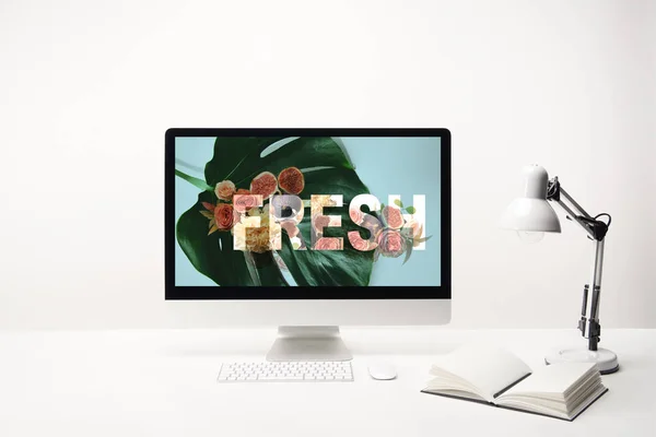 Computador com letras frescas e folha verde no monitor na mesa no fundo branco — Fotografia de Stock