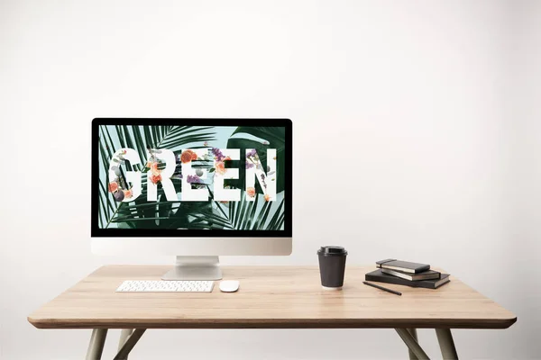 Ordinateur avec feuilles vertes et lettrage vert sur écran sur bureau en bois — Photo de stock