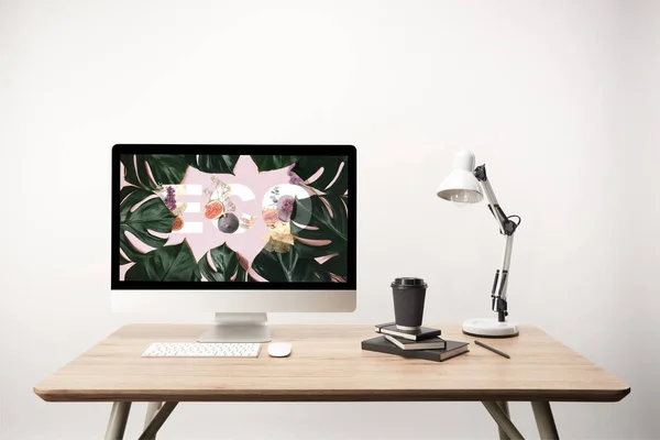 Ordenador con hojas verdes e ilustración ecológica en monitor sobre escritorio de madera — Stock Photo