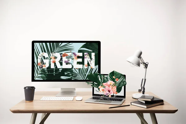 Ordenador con letras verdes y hojas de monstera ilustración en monitor sobre mesa de madera - foto de stock
