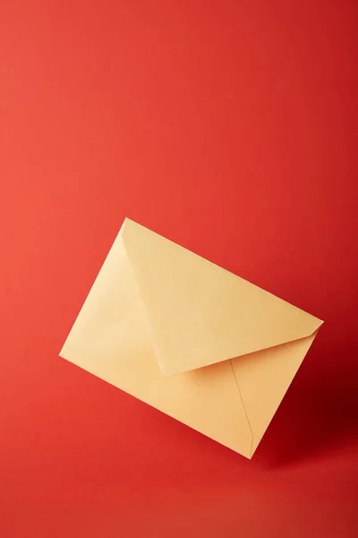 Bright, colorful and yellow envelope on red background with copy space — Stock Photo