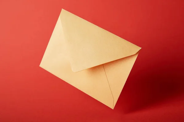 Envelope brilhante, colorido e amarelo no fundo vermelho com espaço de cópia — Fotografia de Stock