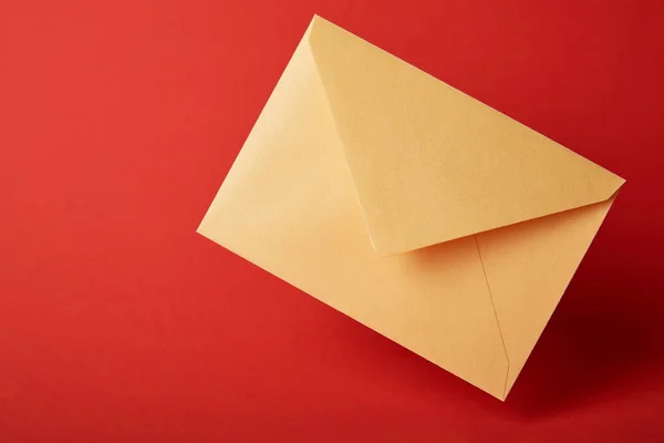 Bright, colorful and yellow envelope on red background with copy space — Stock Photo