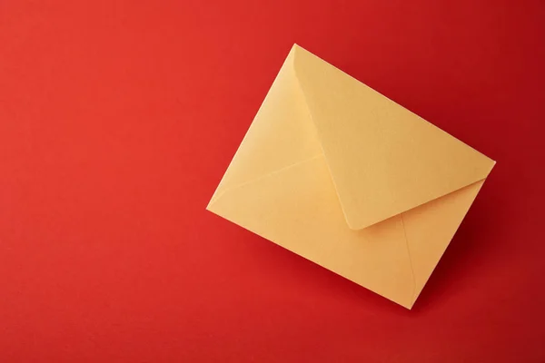 Bright, colorful and yellow envelope on red background with copy space — Stock Photo