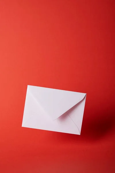 White and empty envelope on bright red background with copy space — Stock Photo