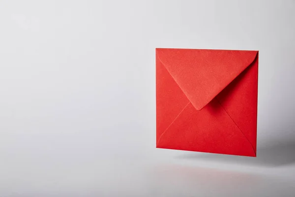 Red and bright envelope on grey background with copy space — Stock Photo