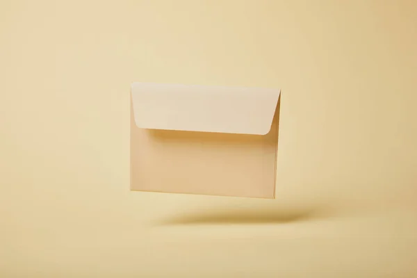 Envelope bege e branco no fundo amarelo com espaço de cópia — Fotografia de Stock