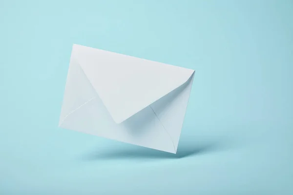 Білий і порожній конверт на синьому фоні з пробілом для копіювання — стокове фото