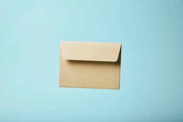 Beige and blank envelope on blue background with copy space — Stock Photo