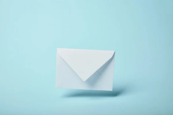 Білий і порожній конверт на синьому фоні з пробілом для копіювання — стокове фото