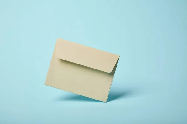 Beige and blank envelope on blue background with copy space — Stock Photo