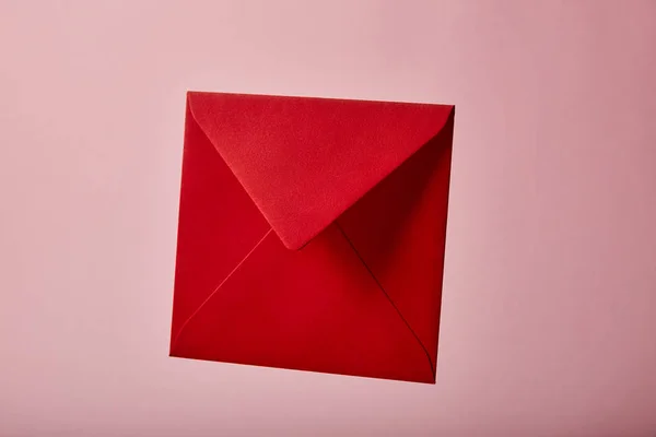 Envelope vermelho e vazio no fundo rosa com espaço de cópia — Fotografia de Stock