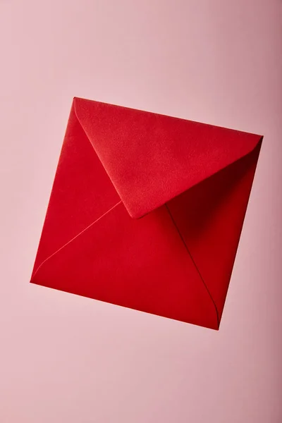 Envelope vermelho e brilhante no fundo rosa com espaço de cópia — Fotografia de Stock