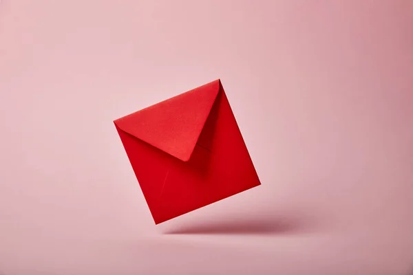 Enveloppe rouge et colorée sur fond rose avec espace de copie — Photo de stock