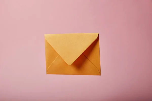 Желтый и яркий конверт на розовом фоне с копировальным пространством — стоковое фото