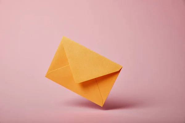 Envelope amarelo e colorido no fundo rosa com espaço de cópia — Fotografia de Stock