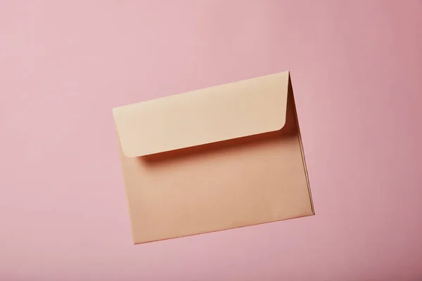 Бежевый и пустой конверт на розовом фоне с копировальным местом — стоковое фото