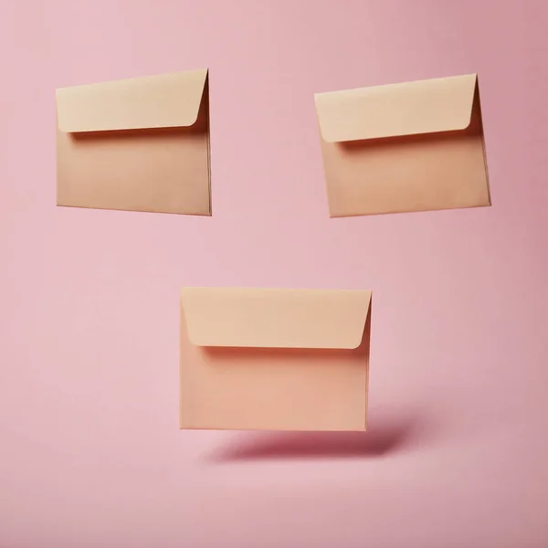 Beige envelopes with copy space on pink and pastel background — Stock Photo