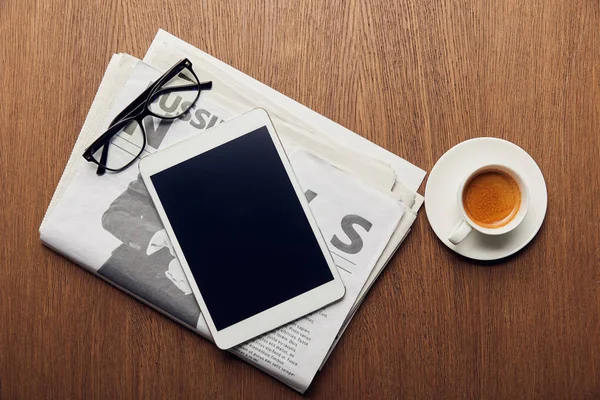 Верхний вид газеты рядом с чашкой кофе, цифровой планшет с чистым экраном и очками — стоковое фото